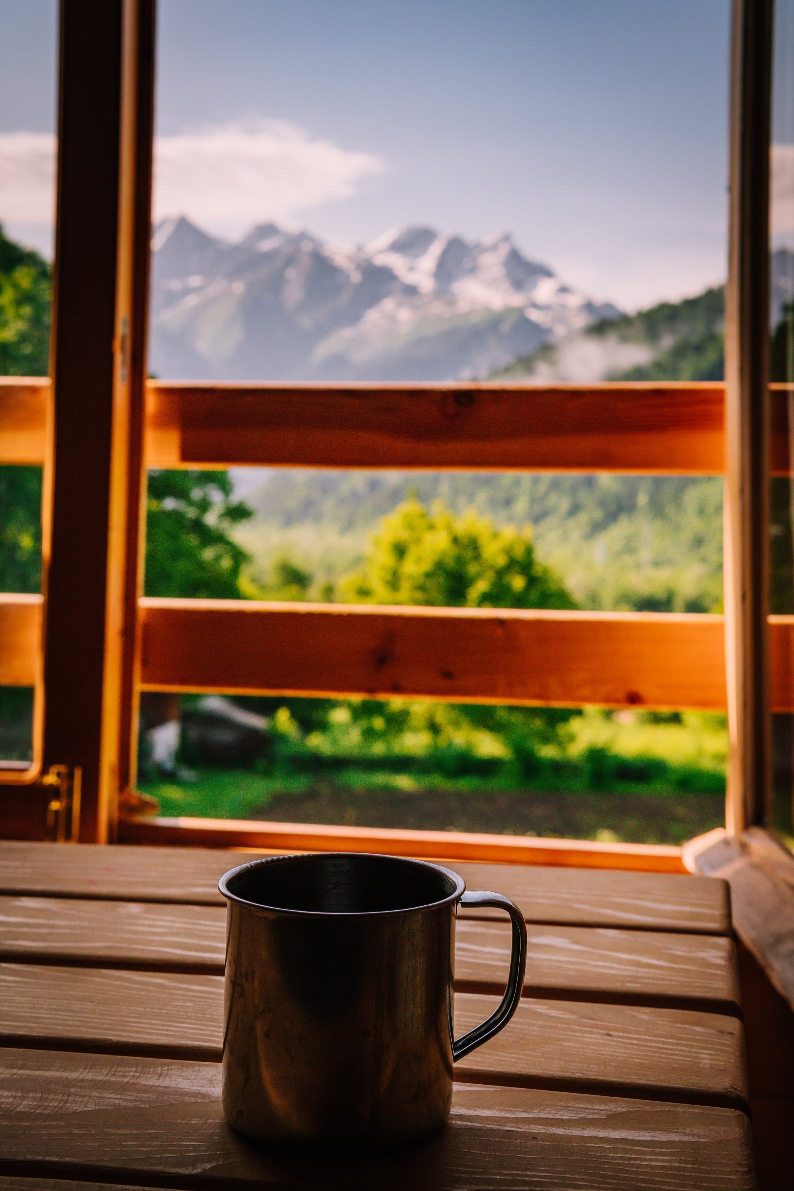Morning coffee on wooden desk with Racha mountain view at Chiora Inn