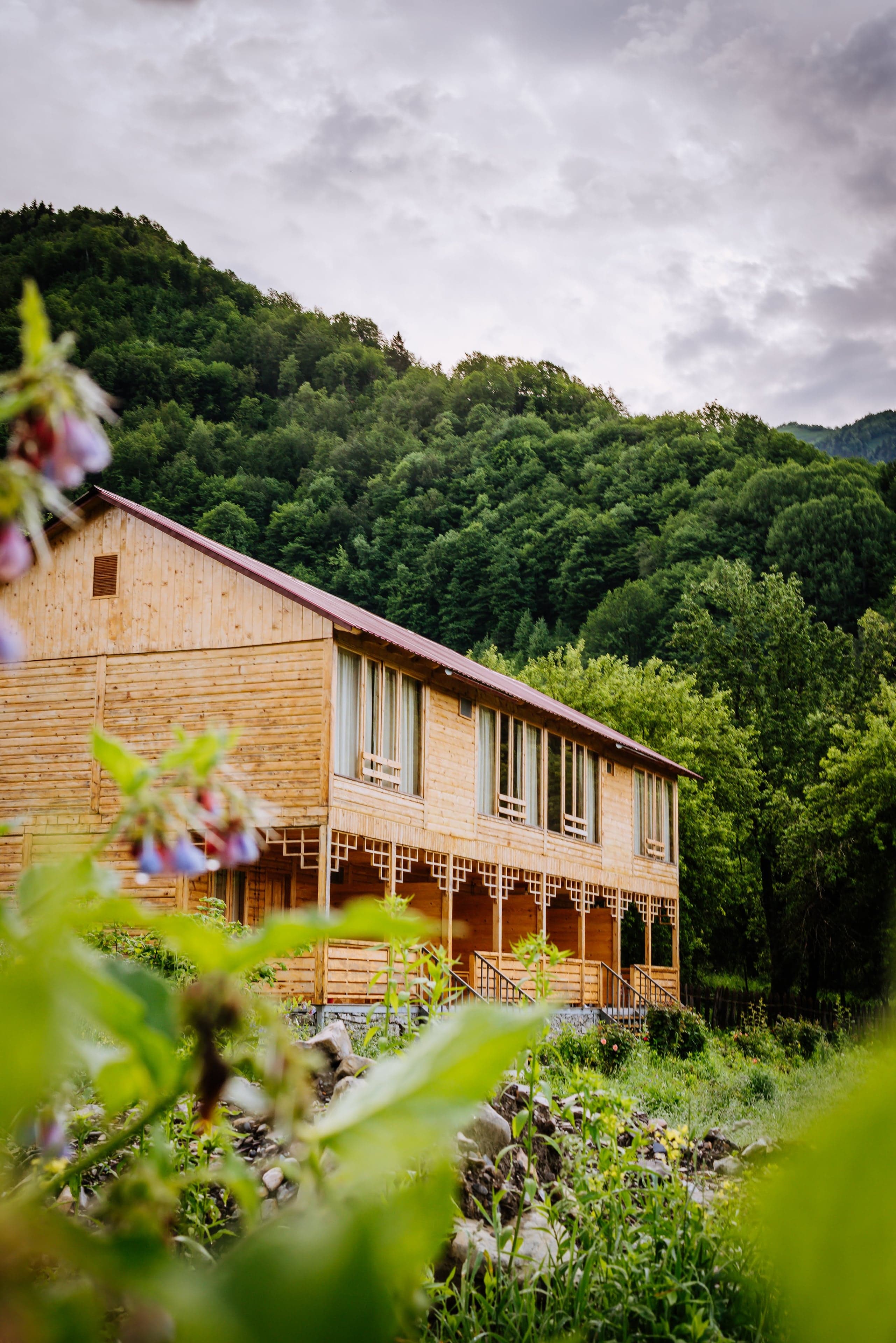 Chiora Inn wooden cabin nestled in green hillside, upper Racha